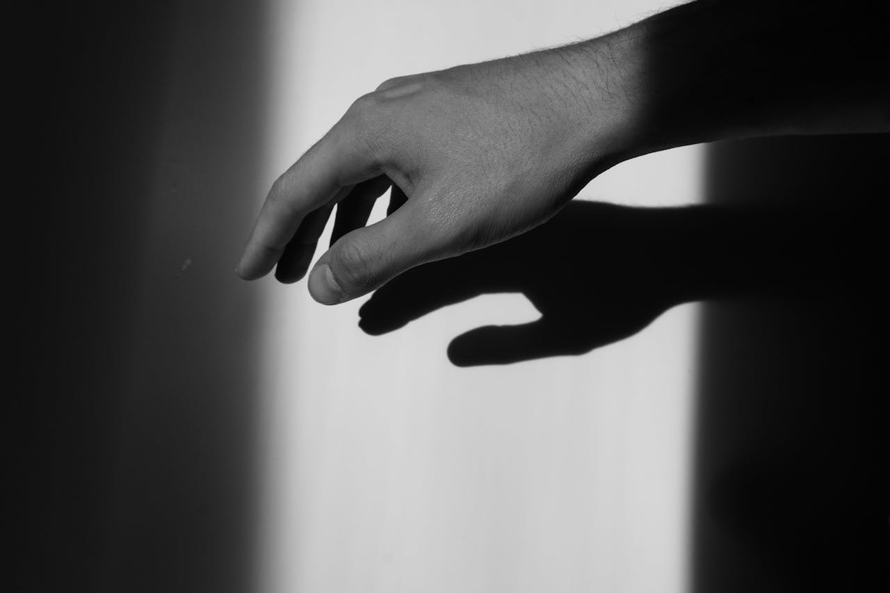 Hand casting a shadow symbolizing depression and emotional processing in CBT therapy