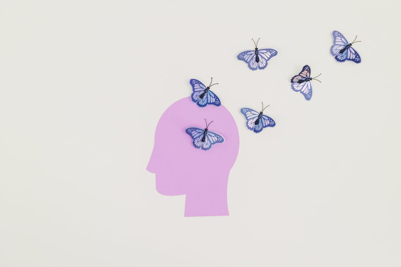 Head silhouette with butterflies representing cognitive behavioral therapy for depression and mindset change